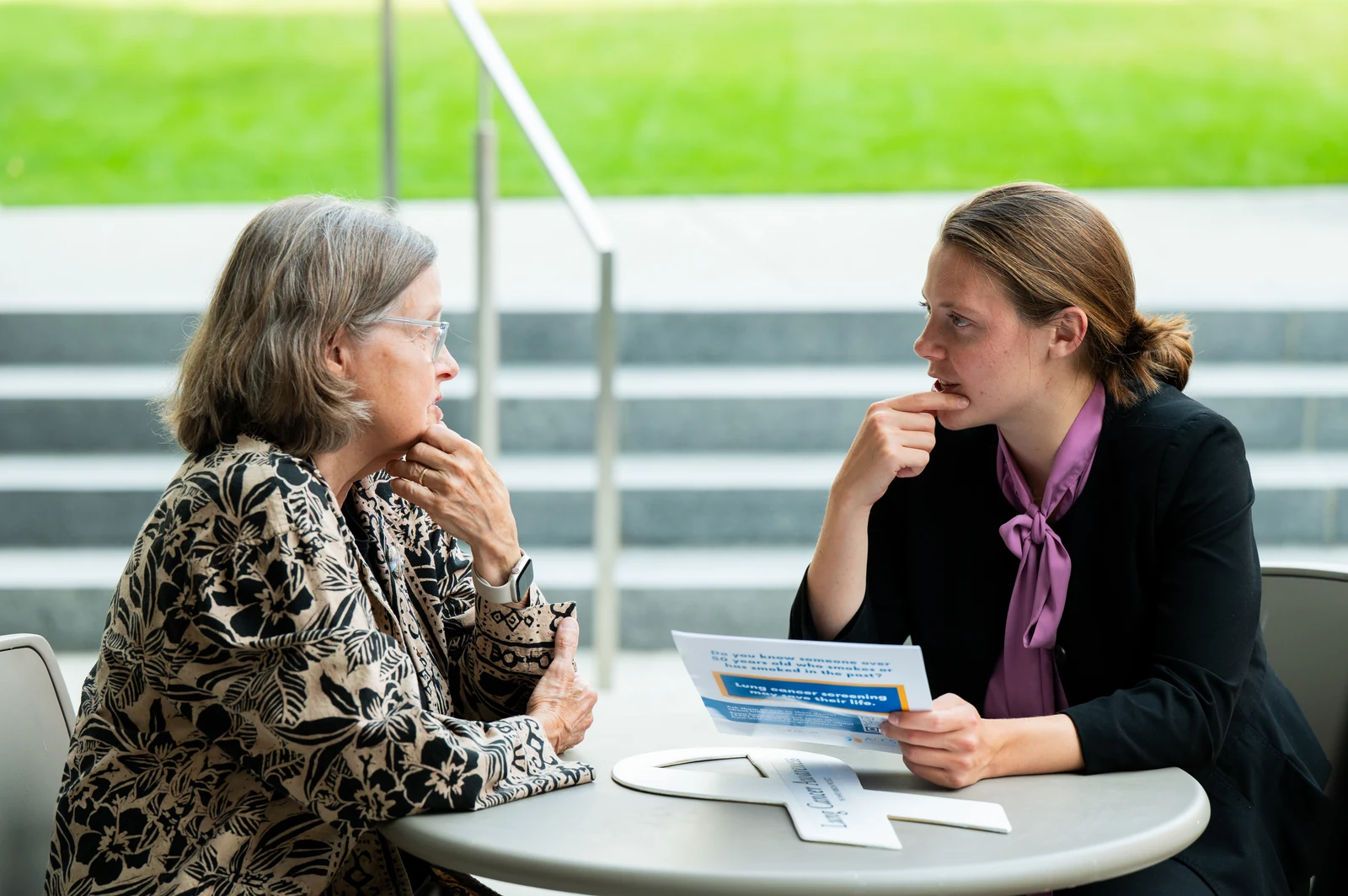 A community member and an ALCSI advocate discussing printed screening information